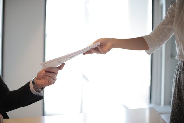 two people exchanging a document